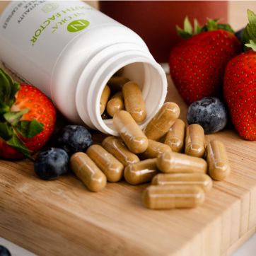 Neora Youth Factor® Vitality Complex bottle and pills shown pictured with berries